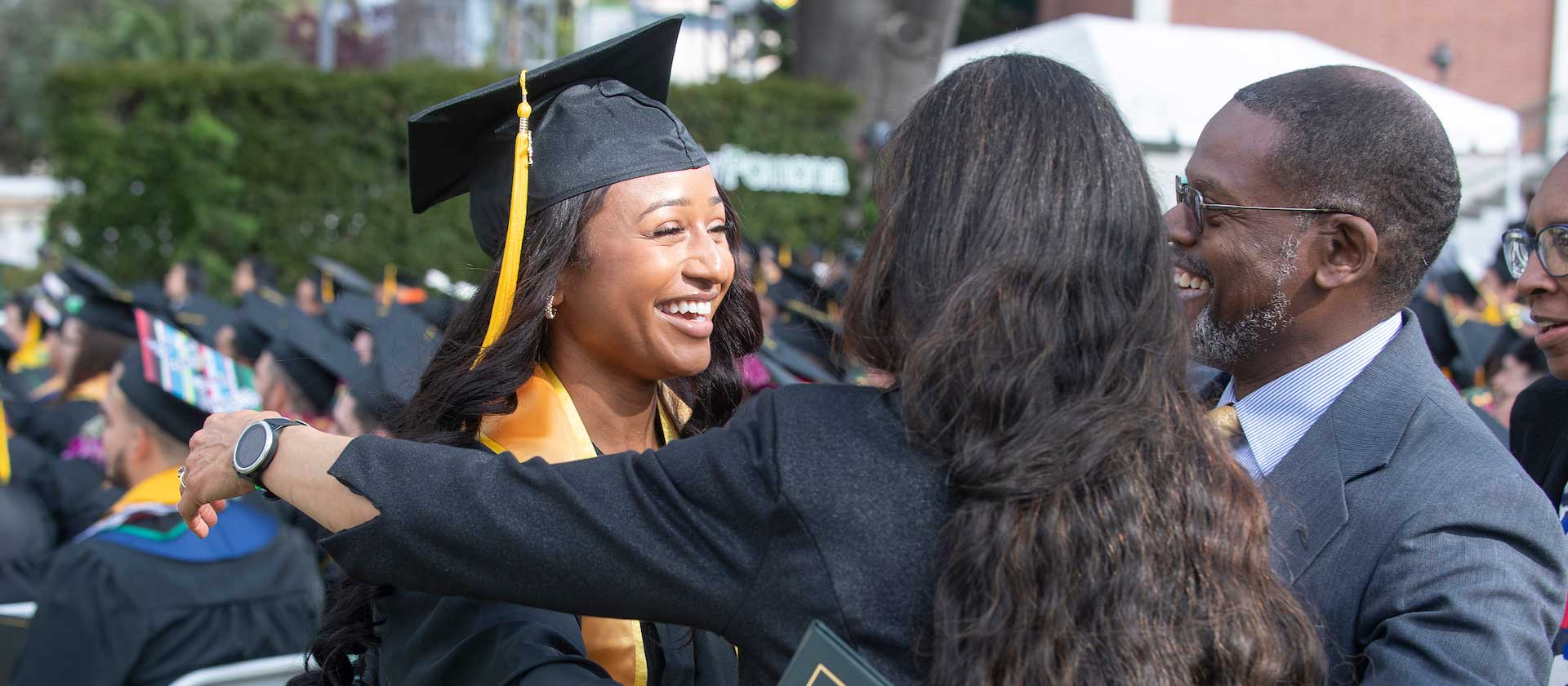 Eliana hugs her parents during commencement.